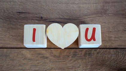 Concept letters I and U made on wooden blocks. Wooden heart.