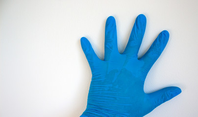 Doctor hand in sterile blue gloves. White background.