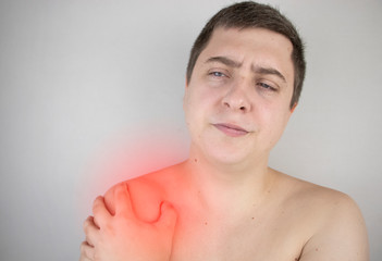 Obraz premium A man suffers from shoulder pain. Shoulder injury, tendonitis, sprain, or tendon inflammation. The concept of acute pain and inflammation in different parts of the body