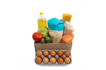 Food donations box isolated on white background. Cabbage, cucumber, tomatoes, flour, sunflower oil,...