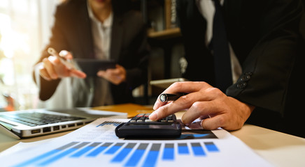 Team business meeting presentation. Hand businessman working project in modern office.Laptop computer and tablet and smart phone on white desk in morning light
