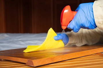 Man with gloves disinfecting a desk in the office.