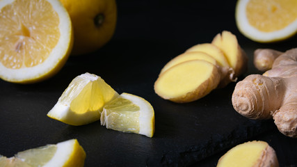 still life, lemon slices and ginger root on a black background