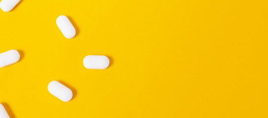 Banner with white pills on yellow background.