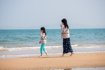 初夏の海で砂遊びをしている子供姉妹