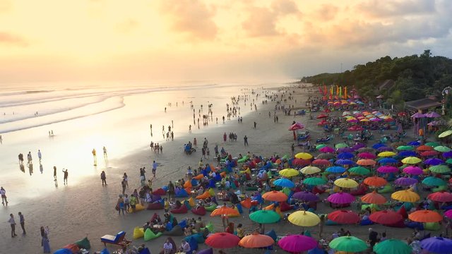 People sitting and walk on the beach and enjoying the party life in Seminyak Beach at sunset. 15 January 2020: Bali, Indonesia.