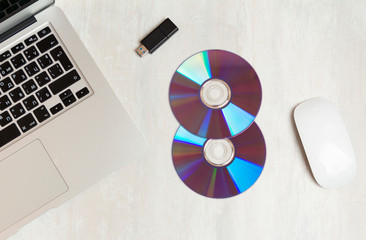 cd, dvd on office desk with mouse and laptop