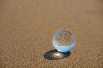 海の海岸にある透明な水晶ガラスボール