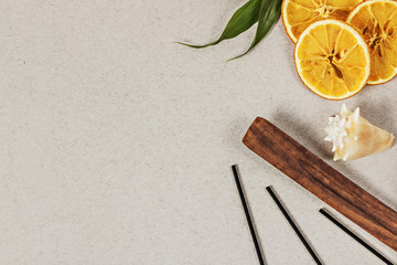 Incense sticks with a stand, sliced orange circles in a wooden bowl on a gray background. Also a seashell.Aromatherapy. The concept of home Spa.
