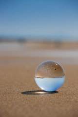 Fototapeta na wymiar 海の海岸にある透明な水晶ガラスボール