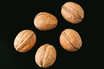 Walnuts with shells on dark background. Background of fresh whole walnuts.