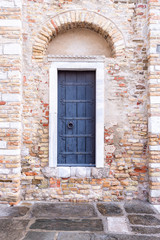 Eine alte Steinmauer mit einer alten Holztür als Hintergrund