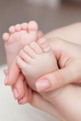 Obraz na płótnie Canvas baby feet in mothers hands