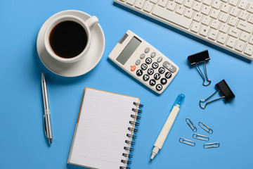 Top view,flat lay,notebook,pen,paperclip,coffee cup or object for office apply concept on blue background.