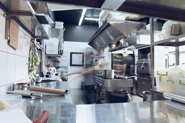 Behind the scenes of brands. The chef cooking in a professional kitchen of a restaurant meal for client or delivery. Open business from the inside. Meals during the quarantine. Hurrying up, motion.