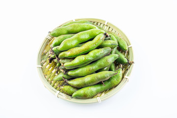 Fresh broad bean pods in a pot on white background