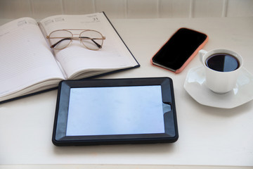 office table desk. Workspace with laptop, diary, mobile, 
glasses, 
the tablet and coffe on white background. Flat lay, top view
