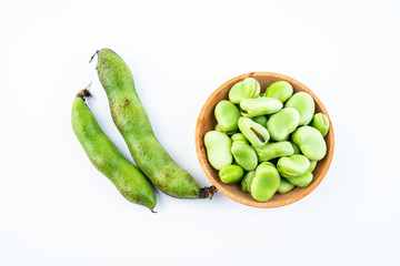 Fresh broad bean pods and broad beans on white background