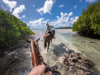 horse riding in blue lagoon sunny day turquoise water Esparto Santo island Vanuatu