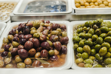 Assortment of olives, pickles and salads on market stand