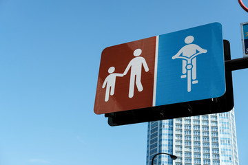 The Adult symbol walks the hand of children signboard and bike lane signboard with blue sky backgrounds