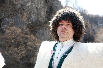 Man posing in white felt cloak