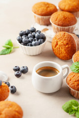 Cup of coffee and Muffins or capcakes with blueberries and mint  on a wooden background.