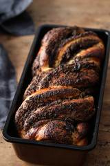 Brioche with poppy seeds on a wooden board. Copy space.