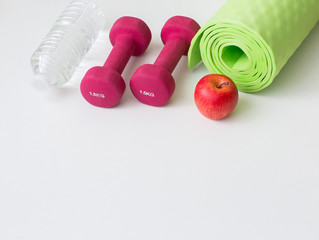 bottle water, yoga mat, apple and dumbbells