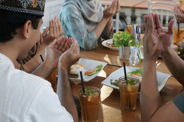 muslim praying for breaking the fast. friend iftar dinner together