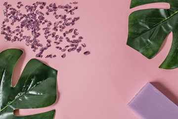 Natural organic cosmetic products with Monstera leaves on a pink background. Flat lay, top view, copy space. The concept of skin care and beauty. Spa home