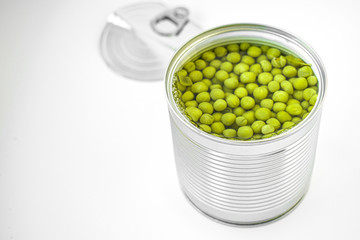 Iron can with green peas in brine on a white background
