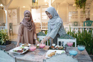 beautiful muslim woman preparing dining table for breaking the fast dinner with family