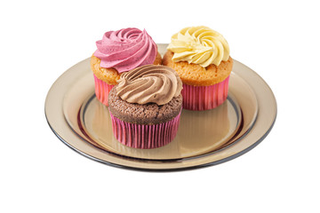 different cupcakes on a brown glass plate isolated on white