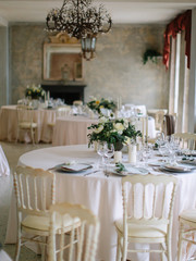 Fototapeta na wymiar wedding decor, served tables, ivory, with candles, glasses, beautiful wooden tables, inside the Italian old Villa