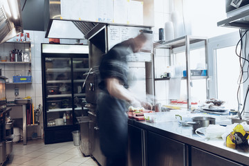 Behind the scenes of brands. The chef cooking in a professional kitchen of a restaurant meal for...