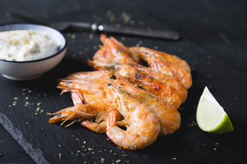 Fried shrimp with sauce on a black plate