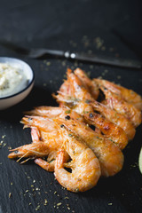 Fried shrimp with sauce on a black plate