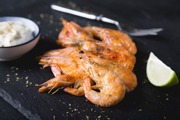 Fried shrimp with sauce on a black plate