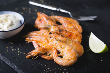 Fried shrimp with sauce on a black plate