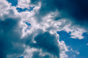 Naklejka na ściany i meble Blue sunny sky covered by black clouds.