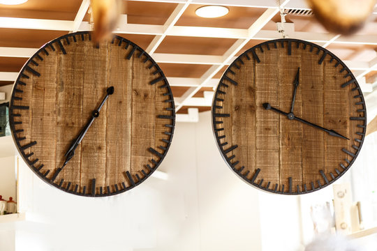 Due Orologi in legno appesi al soffitto con due orari diversi in riferimento a due località differenti