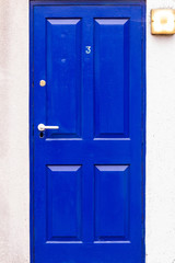 Blue wooden front door with the number 3 in London, UK