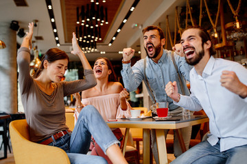 Group of friends watching game in cafe