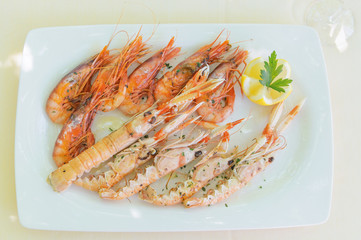 Shrimp and Spiny Lobster with Lemon Slice on White Plate