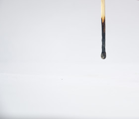 Inverted burned lonely match on a white background.
