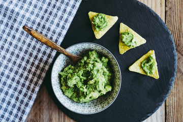 Guacamole fait maison avec des tortillas chips de maïs - Préparation traditionnel mexicaine épicée