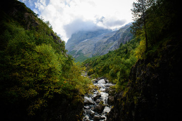 Fototapeta na wymiar River in a gorge on a background of mountains in the clouds.