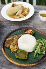 indonesian nasi rames served on plate with banana leaf