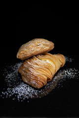 dessert pastry  with powder sugar  black background 